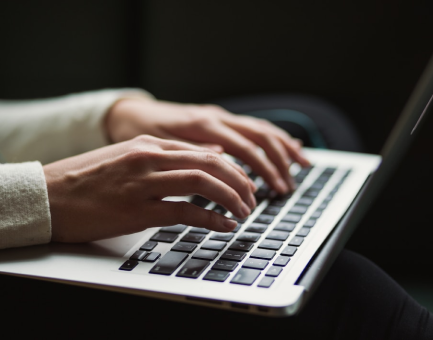 someone typing using a laptop image